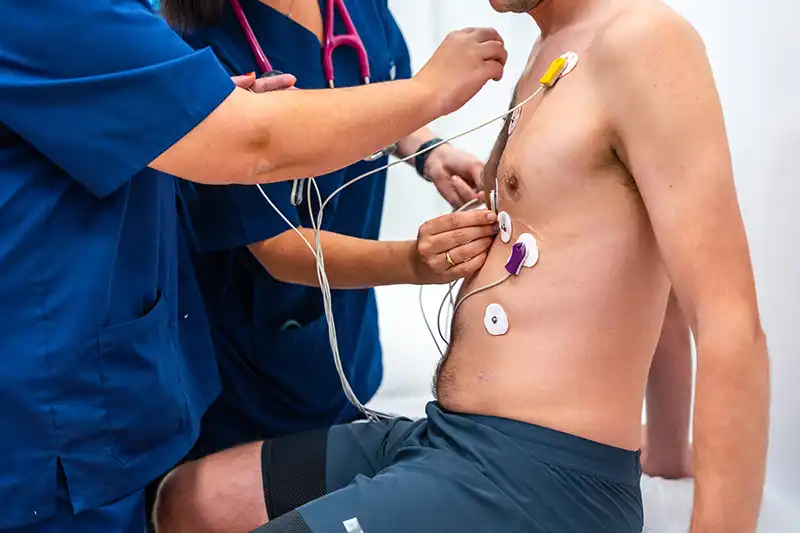 cardiologists placing electrodes to a patient for EKG