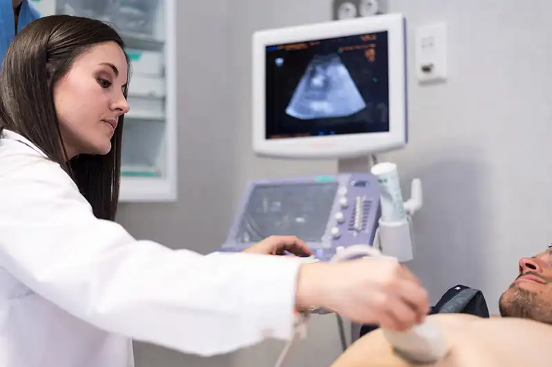 doctor examining patient with ultrasound diagnostic testing