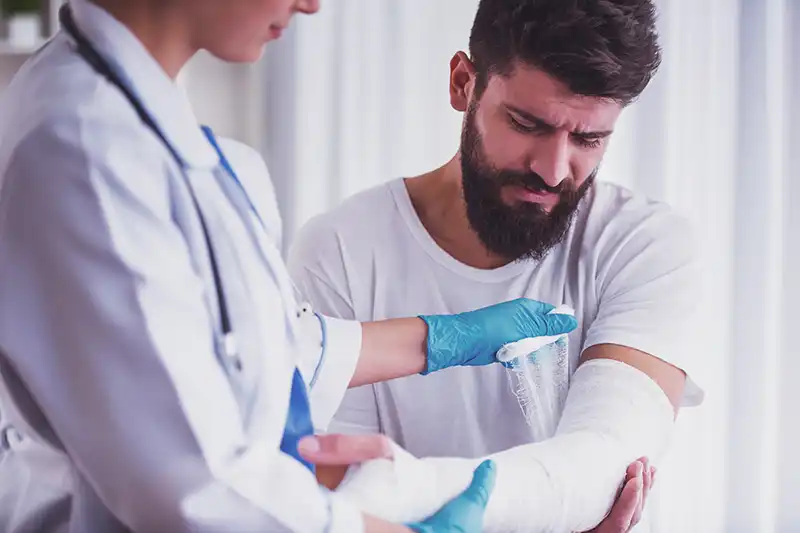 no fault workers comp doctor bandaging mans arm