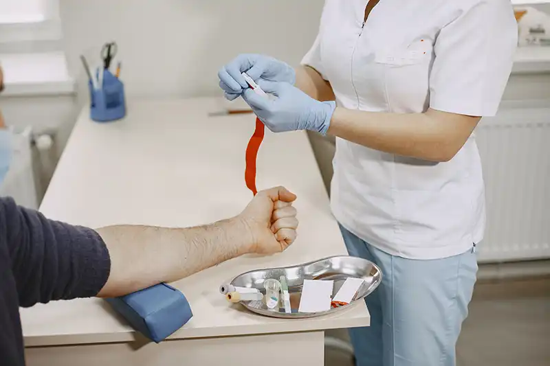 nurse taking blood sample from patient for diagnostic testing