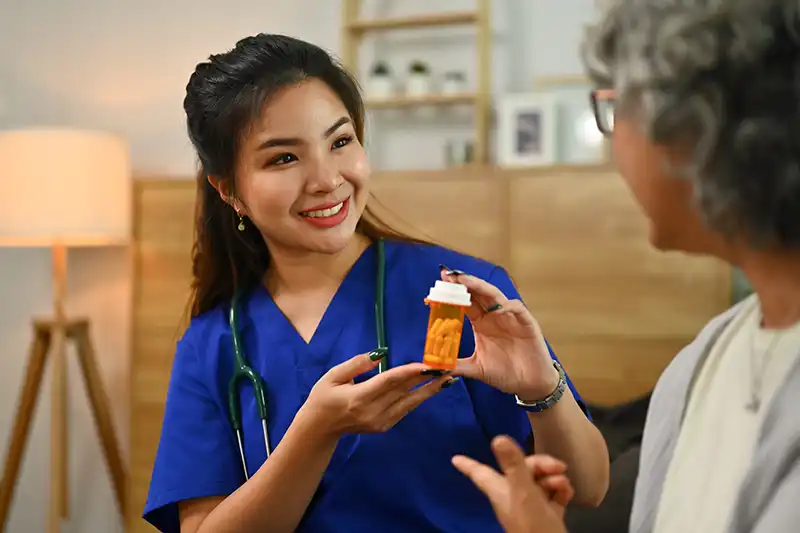 primary care nurse explaining medicine dosage to senior patient