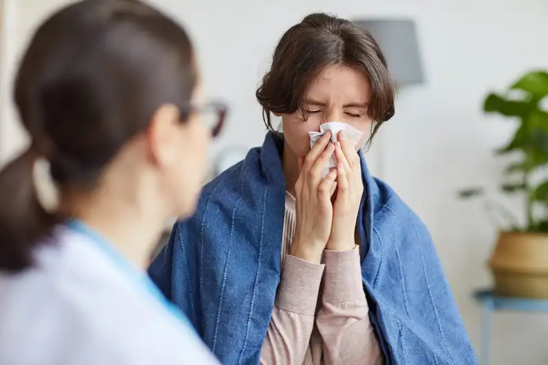 primary care provider with patient with a cold